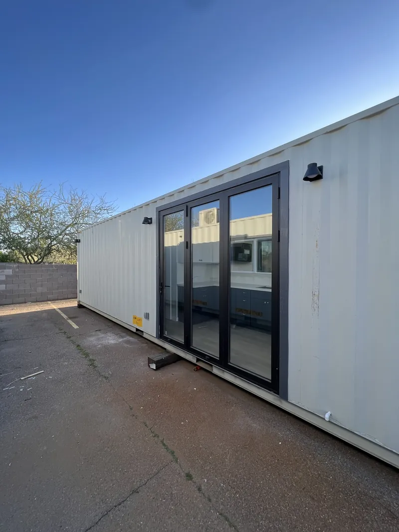 White container home with two full-height glass sliders