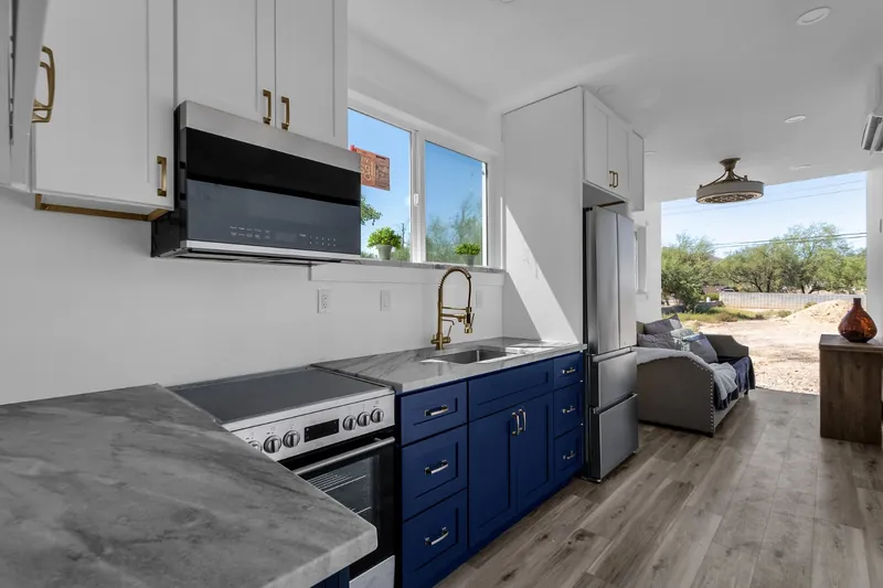 Navy shaker kitchen inside a container home with butcher block counters